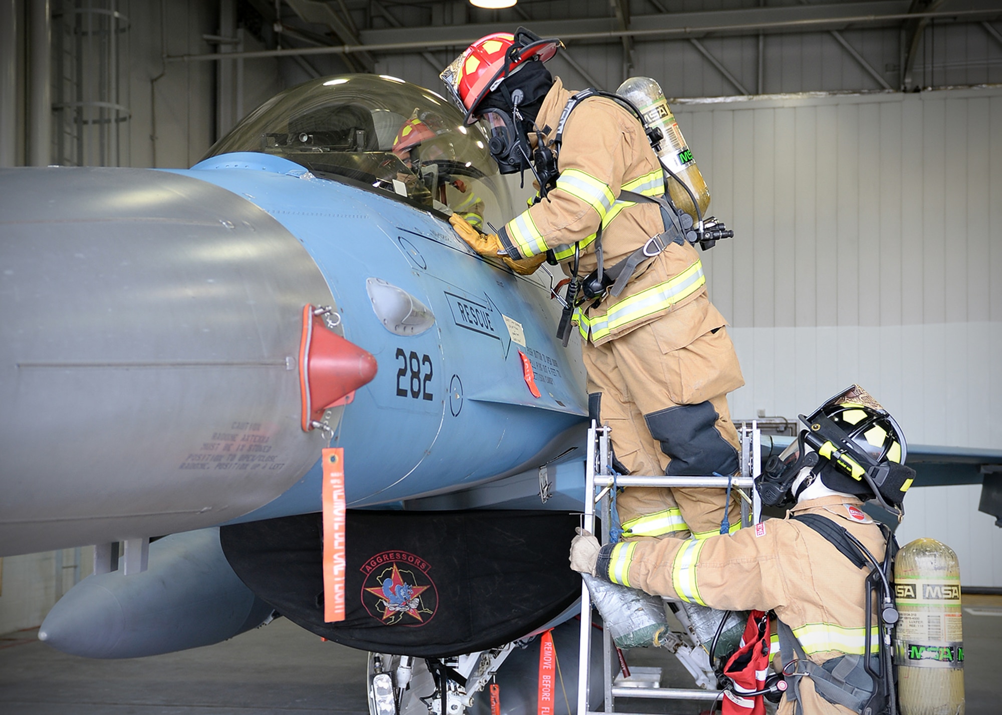 Staff Sgt. Alan Drake, 354th Civil Engineer Squadron lead firefighter, peers into the cockpit of an F-16 Fighting Falcon at a simulated unconscious pilot during training Sept. 19, 2013, Eielson Air Force Base, Alaska. Although firefighters start each shift checking equipment, they receive a different surprise training scenario to sharpen their skills every day. (U.S. Air Force photo by Senior Airman Shawn Nickel/Released)