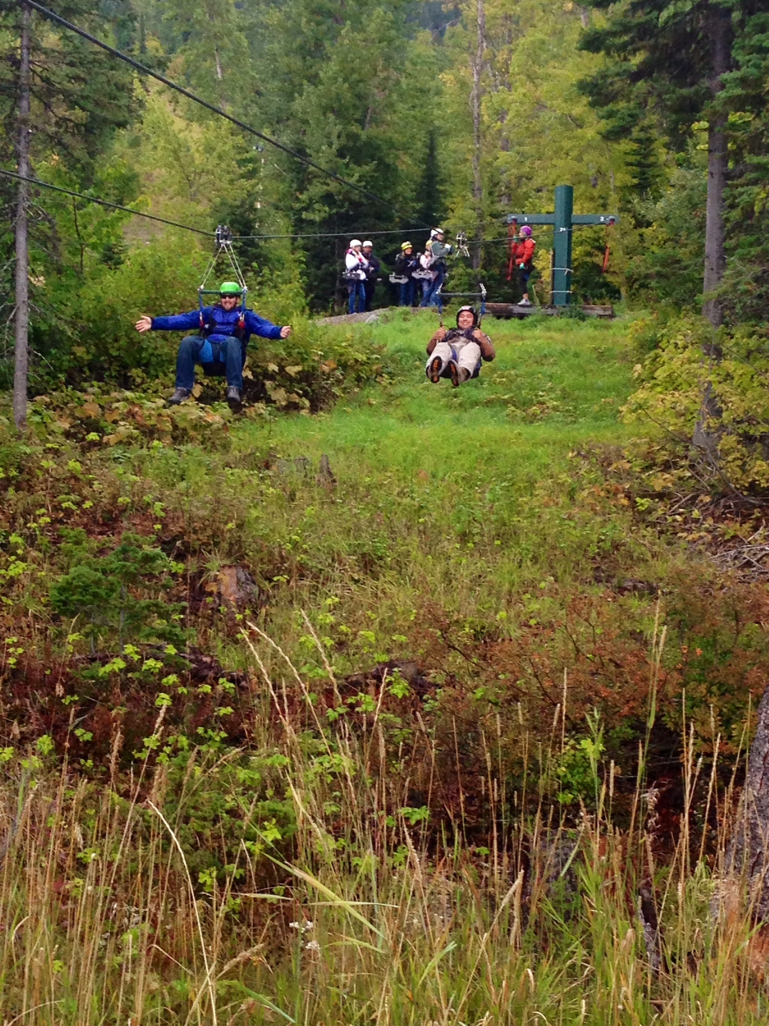 John Kuehl, Whitefish retreat attendee (left), races Senior Airman David Blunk, 341st Missile Security Forces Squadron member, on the second of several zip-line stations at Whitefish Mountain Resort in Whitefish Mont. on Sept 28. The longest zip-line at the resort is more than 300-feet high and 1,900-feet long. (U.S. Air Force Photo/Airman 1st Class Collin Schmidt)      