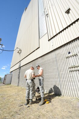 Airman 1st Class Trent McBrayer, 341st Civil Engineer Squadron heating ventilation and air conditioning technician, (right) helps Senior Airman Dustin Schierman, 341st CES HVAC technician, assemble an electrical box before attaching it to a unistrut. The heating plant pumps high temperature hot water through more than 21 miles of tubing throughout Malmstrom Air Force Base. (U.S. Air Force Photo/Airman 1st Class Collin Schmidt)  