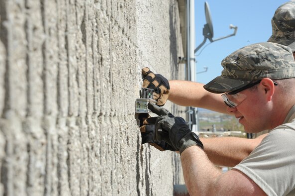 Senior Airman Trevor Walter, 341st Civil Engineering Squadron heating ventilation and air conditioning journeyman, mounts an external unistrut to the heating plant wall to hold conduit in place for a miniature split HVAC system. The system being installed will be used to cool vital computer-based equipment that aids in controlling the heating plant’s operations. (U.S. Air Force Photo/Airman 1st Class Collin Schmidt)  