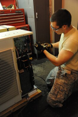 Senior Airman Dustin Schierman, 341st Civil Engineer Squadron heating ventilation and air conditioning technician, (left) assists Senior Airman Trevor Walter, 341st CES HVAC journeyman, in mounting a unistrut to support conduit for a miniature split air conditioning system at the heating plant on Malmstrom Air Force Base. The two systems were installed in the heating plant to keep vital system support equipment in a temperature-controlled environment. (U.S. Air Force Photo/Airman 1st Class Collin Schmidt)   