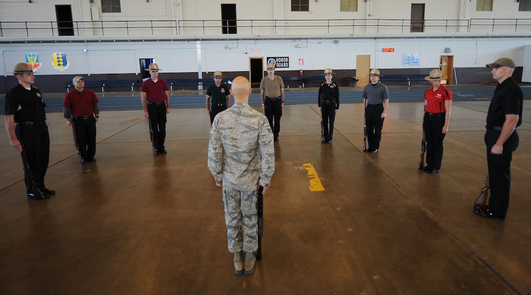 Senior Airman Bradley Sutter, 28th Logistics Readiness Squadron fuels distribution technician, instructs Pennington County sheriffs on how to handle a rifle during a presentation of the colors in the Pride Hangar at Ellsworth Air Force Base, S.D. Sept. 30, 2013. Nine Pennington County sheriffs participated in an honor guard training course learning how to perform at events including parades and funerals. (U.S. Air Force photo by Airman 1st Class Rebecca Imwalle/Released)