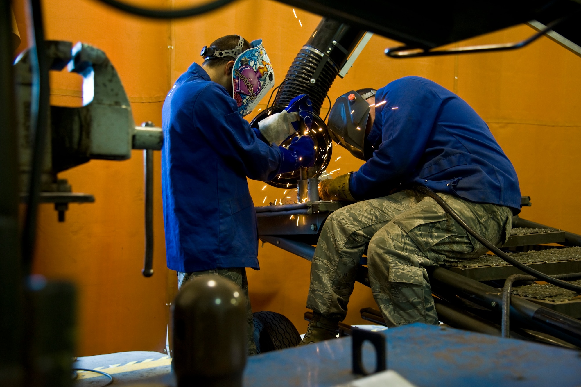 Airmen 1st Class’ Logan Stebenne (left) and Abraham Vidulich, 22nd Maintenance Squadron fabrication flight metals technicians, repair a B1 stand Sept. 26, 2013, at McConnell Air Force Base, Kan. Metals technicians work in pairs when welding as a safety measure and to increase the accuracy. (US Air Force photo/Airman 1st Class John Linzmeier)