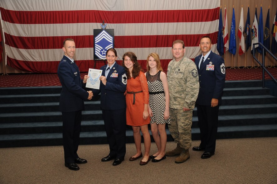 Chief Master Sgt. Tiffany Berard, 2nd Logistics Readiness Squadron, receives a certificate of promotion from Col. Leland Bohannon, 2nd Bomb Wing vice commander, and Chief Master Sgt. Curtis Storms, 2nd Bomb Wing command chief, during the September Wing Promotion Ceremony on Barksdale Air Force Base, La., Sept. 30, 2013. (U.S. Air Force photo/Senior Airman Sean Martin)