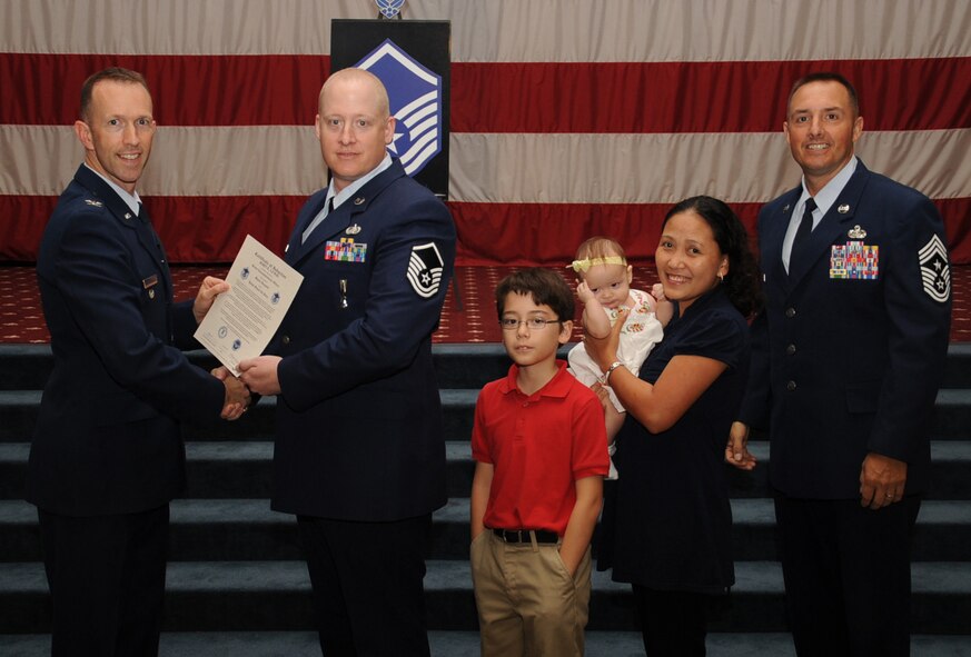 Master Sgt. John Lewis, 2nd Communications Squadron , receives a certificate of promotion from Col. Leland Bohannon, 2nd Bomb Wing vice commander, and Chief Master Sgt. Curtis Storms, 2nd Bomb Wing command chief, during the September Wing Promotion Ceremony on Barksdale Air Force Base, La., Sept. 30, 2013. (U.S. Air Force photo/Senior Airman Sean Martin)
