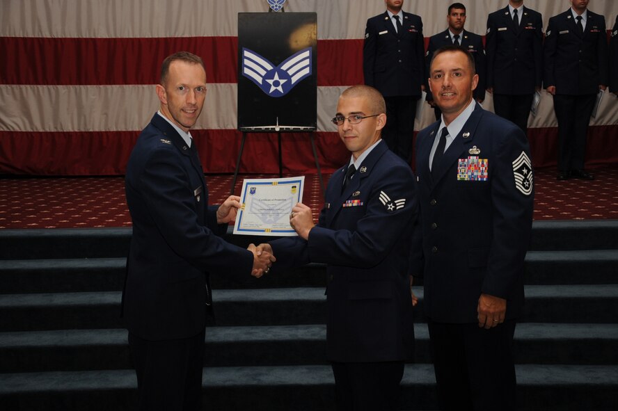 Senior Airman Christopher Tindall, 2nd Maintenance Squadron, receives a certificate of promotion from Col. Leland Bohannon, 2nd Bomb Wing vice commander, and Chief Master Sgt. Curtis Storms, 2nd Bomb Wing command chief, during the September Wing Promotion Ceremony on Barksdale Air Force Base, La., Sept. 30, 2013. (U.S. Air Force photo/Senior Airman Sean Martin)