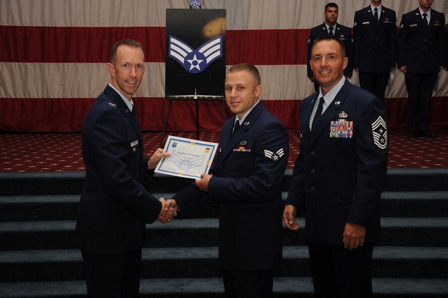 Senior Airman David Reid, 2nd Maintenance Squadron, receives a certificate of promotion from Col. Leland Bohannon, 2nd Bomb Wing vice commander, and Chief Master Sgt. Curtis Storms, 2nd Bomb Wing command chief, during the September Wing Promotion Ceremony on Barksdale Air Force Base, La., Sept. 30, 2013. (U.S. Air Force photo/Senior Airman Sean Martin)