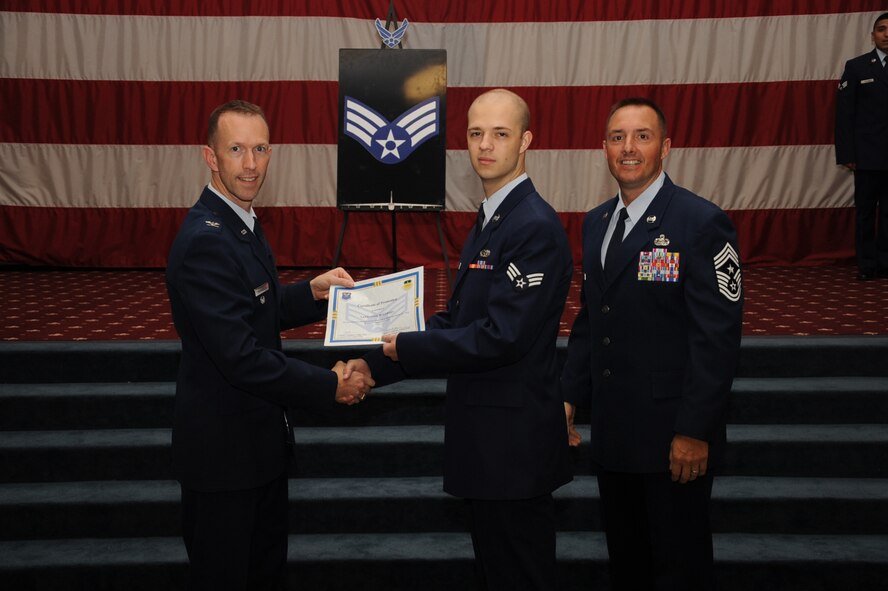 Senior Airman Nathaniel Gerdes, 2nd Maintenance Squadron, receives a certificate of promotion from Col. Leland Bohannon, 2nd Bomb Wing vice commander, and Chief Master Sgt. Curtis Storms, 2nd Bomb Wing command chief, during the September Wing Promotion Ceremony on Barksdale Air Force Base, La., Sept. 30, 2013. (U.S. Air Force photo/Senior Airman Sean Martin)
