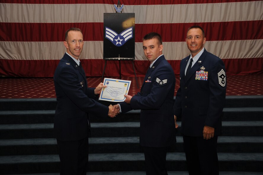 Senior Airman Joshua Desmarteau,  2nd Maintenance Squadron, receives a certificate of promotion from Col. Leland Bohannon, 2nd Bomb Wing vice commander, and Chief Master Sgt. Curtis Storms, 2nd Bomb Wing command chief, during the September Wing Promotion Ceremony on Barksdale Air Force Base, La., Sept. 30, 2013. (U.S. Air Force photo/Senior Airman Sean Martin)