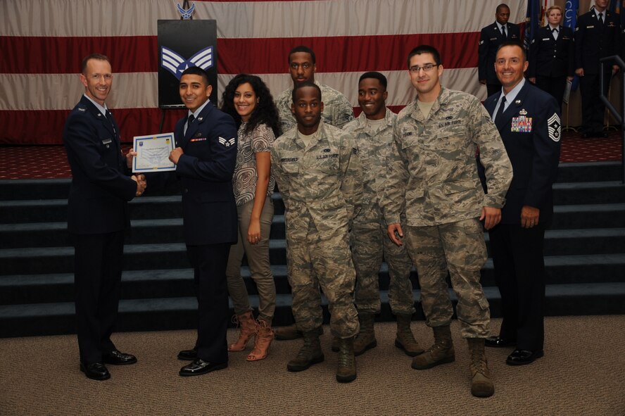 Senior Airman Squadron Leonard Avalos, 2nd Maintenance Squadron, receives a certificate of promotion from Col. Leland Bohannon, 2nd Bomb Wing vice commander, and Chief Master Sgt. Curtis Storms, 2nd Bomb Wing command chief, during the September Wing Promotion Ceremony on Barksdale Air Force Base, La., Sept. 30, 2013. (U.S. Air Force photo/Senior Airman Sean Martin)
