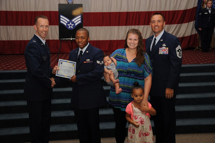 Senior Airman Anthony Moultrie, 2nd Logistics Readiness Squadron, receives a certificate of promotion from Col. Leland Bohannon, 2nd Bomb Wing vice commander, and Chief Master Sgt. Curtis Storms, 2nd Bomb Wing command chief, during the September Wing Promotion Ceremony on Barksdale Air Force Base, La., Sept. 30, 2013. (U.S. Air Force photo/Senior Airman Sean Martin)