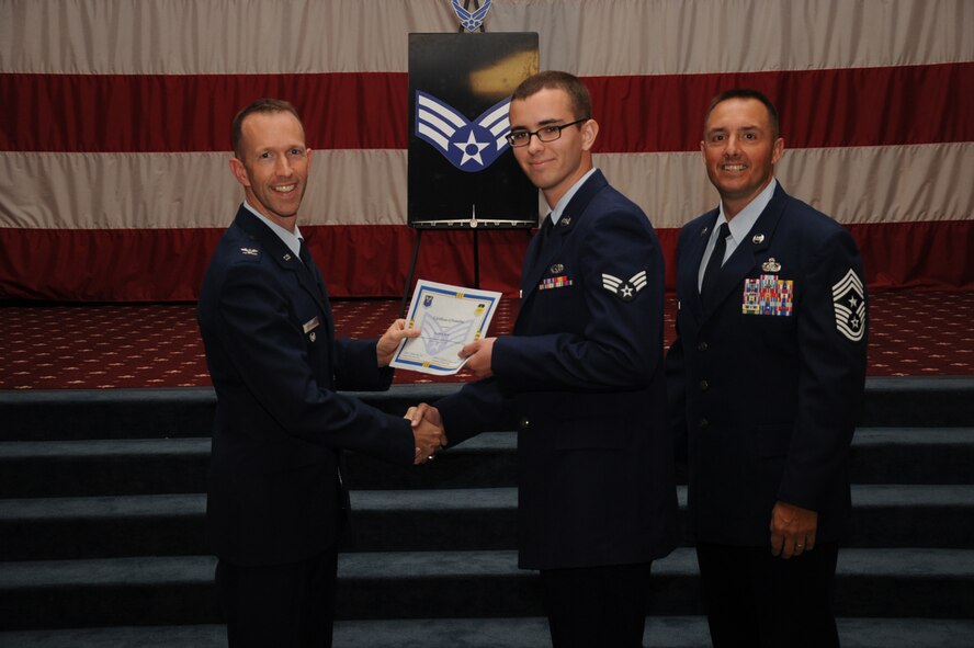 Senior Airman David Wine, 2nd Aircraft Maintenance Squadron, receives a certificate of promotion from Col. Leland Bohannon, 2nd Bomb Wing vice commander, and Chief Master Sgt. Curtis Storms, 2nd Bomb Wing command chief, during the September Wing Promotion Ceremony on Barksdale Air Force Base, La., Sept. 30, 2013. (U.S. Air Force photo/Senior Airman Sean Martin)