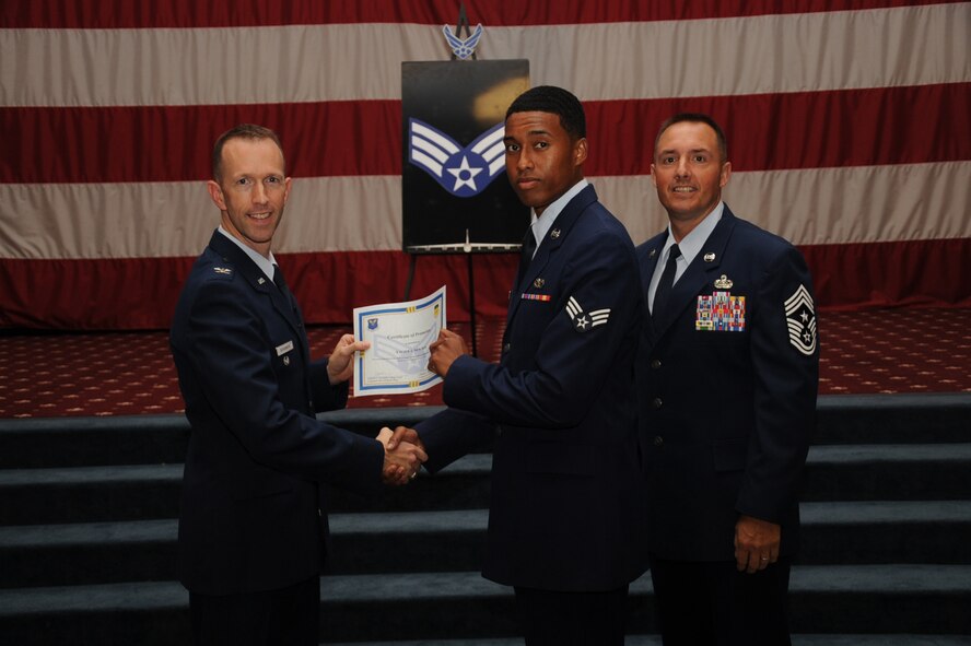 Senior Airman Xavier Newton, 2nd Civil Engineer Squadron, receives a certificate of promotion from Col. Leland Bohannon, 2nd Bomb Wing vice commander, and Chief Master Sgt. Curtis Storms, 2nd Bomb Wing command chief, during the September Wing Promotion Ceremony on Barksdale Air Force Base, La., Sept. 30, 2013. (U.S. Air Force photo/Senior Airman Sean Martin)
