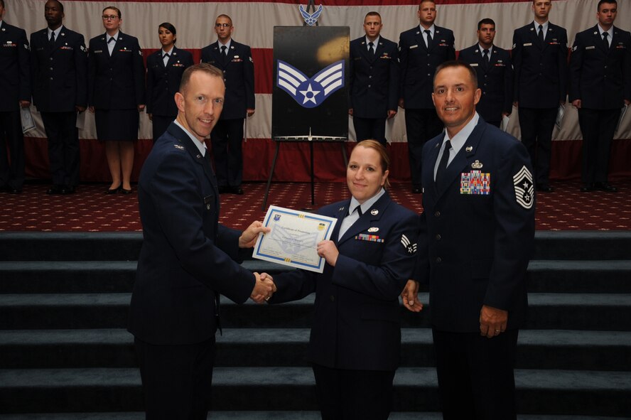 Senior Airman Natalya Wallet, 2nd Security Forces Squadron, receives a certificate of promotion from Col. Leland Bohannon, 2nd Bomb Wing vice commander, and Chief Master Sgt. Curtis Storms, 2nd Bomb Wing command chief, during the September Wing Promotion Ceremony on Barksdale Air Force Base, La., Sept. 30, 2013. (U.S. Air Force photo/Senior Airman Sean Martin)