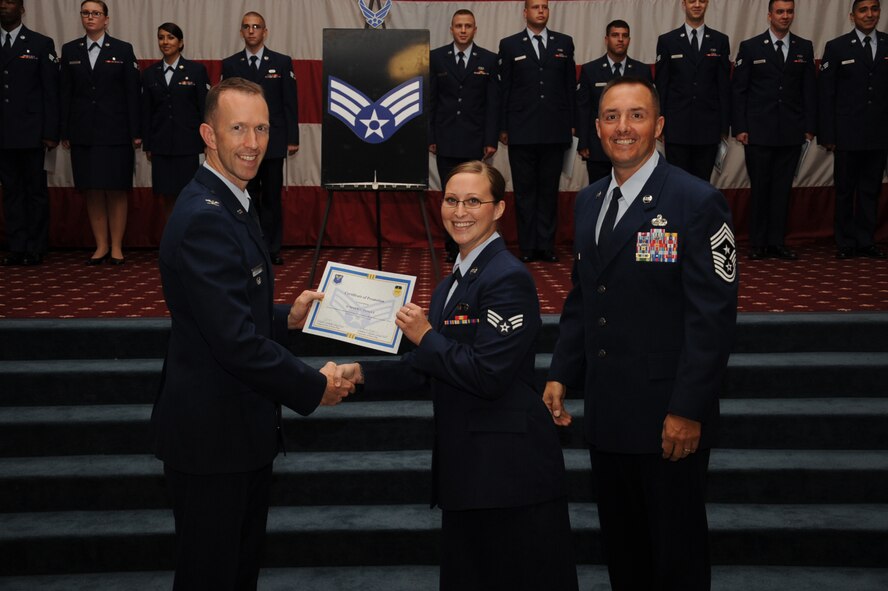 Senior Airman Summer Pangle, 2nd Operation Support Squadron, receives a certificate of promotion from Col. Leland Bohannon, 2nd Bomb Wing vice commander, and Chief Master Sgt. Curtis Storms, 2nd Bomb Wing command chief, during the September Wing Promotion Ceremony on Barksdale Air Force Base, La., Sept. 30, 2013. (U.S. Air Force photo/Senior Airman Sean Martin)
