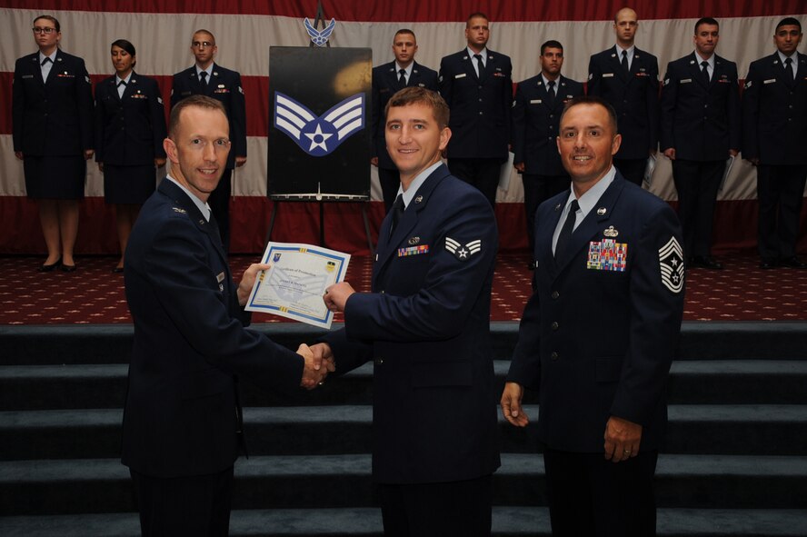 Senior Airman Jeffrey Manuel, 2nd Munitions Squadron, receives a certificate of promotion from Col. Leland Bohannon, 2nd Bomb Wing vice commander, and Chief Master Sgt. Curtis Storms, 2nd Bomb Wing command chief, during the September Wing Promotion Ceremony on Barksdale Air Force Base, La., Sept. 30, 2013. (U.S. Air Force photo/Senior Airman Sean Martin)