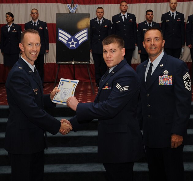 Senior Airman Erik Riley, 26th Operational Weather Squadron, receives a certificate of promotion from Col. Leland Bohannon, 2nd Bomb Wing vice commander, and Chief Master Sgt. Curtis Storms, 2nd Bomb Wing command chief, during the September Wing Promotion Ceremony on Barksdale Air Force Base, La., Sept. 30, 2013. (U.S. Air Force photo/Senior Airman Sean Martin)
