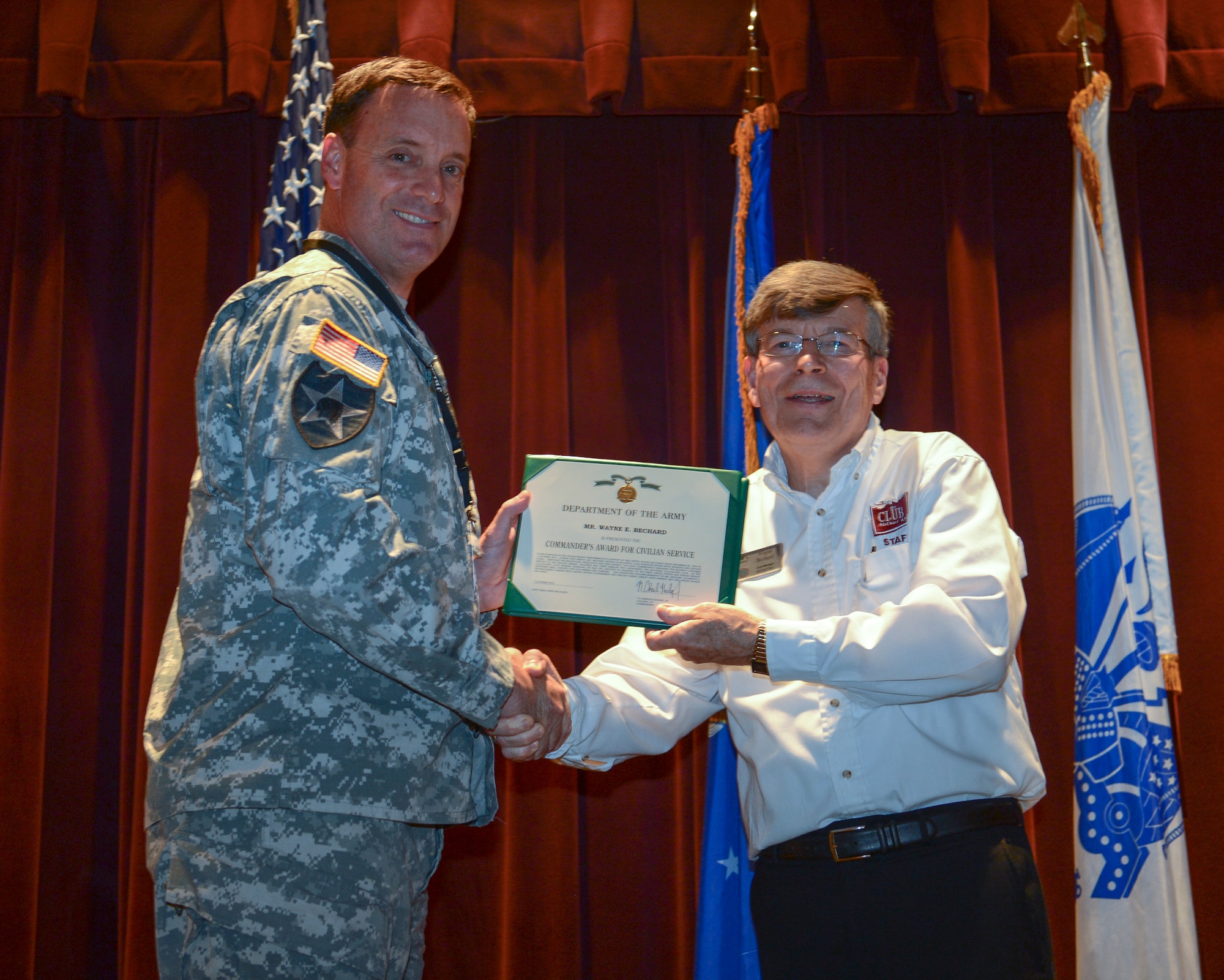 Col. Chuck Hodges, Joint Base Lewis-McChord installation commander, presents Wayne Bechard, McChord Club manager, with the Commander’s Award for Civilian Service award, during Bechard’s retirement ceremony, Oct. 1, 2013, at Joint Base Lewis-McChord, Wash. Bechard served 43 years with the Department of Defense, as a civilian, and as both an active duty and Reserve Airman. (U.S. Air Force photo/Airman 1st Class Jacob Jimenez)