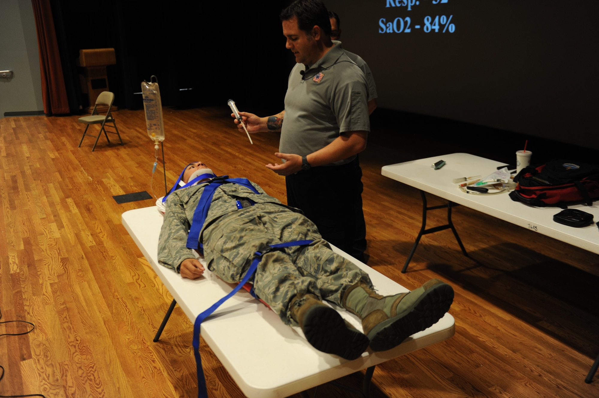 U.S. Air Force Airman 1st Class Joseph Garcia, 317th Aircraft Maintenance Squadron, lays on a table while, Joe McCluan, a firefighter and paramedic, shows him a chest tube during a briefing Sept. 18, 2013, at the base theater on Dyess Air Force Base, Texas.  McCluan is the Assistant Director of the program Stay Alive from Education, better known as S.A.F.E. He went through certain steps that first responders must go through when arriving on scene of a vehicle accident.(U.S. Air Force photo by Airman 1st Class Alexander Guerrero/Released)
