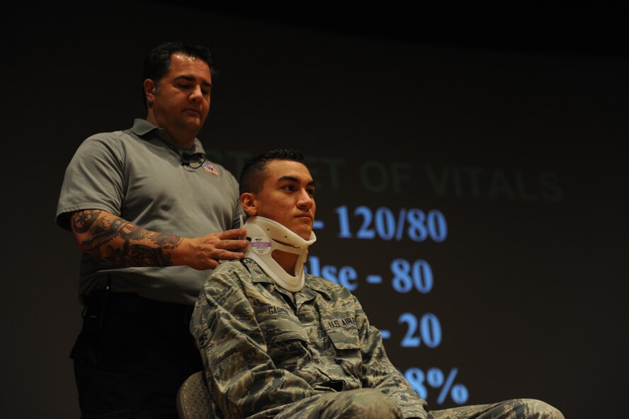 Joe McCluan, a firefighter and paramedic from Orlando, Fla., puts a neck brace on U.S. Air Force Airman 1st Class Joseph Garcia, 317th Aircraft Maintenance Squadron, during a briefing Sept. 18, 2013, at the base theater on Dyess Air Force Base, Texas. McCluan is the Assistant Director of the program Stay Alive from Education, better known as S.A.F.E. The program is presented all over the world at high schools, colleges, military bases and to professional sports teams, hoping to encourage good decision makein when getting behind the wheel of a motor vehicle.(U.S. Air Force photo by Airman 1st Class Alexander Guerrero/Released)