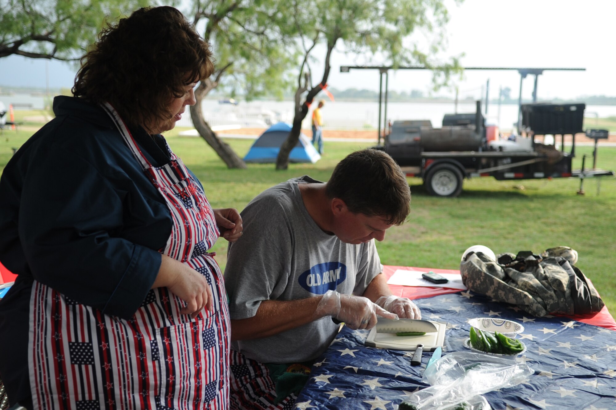 SAN ANGELO, Texas -- Kimberly Allen watches her husband as he cuts jalapenos for their chili during the 40th Annual Armed Forces Chili Cookoff at the Goodfellow Air Force Base Recreation Camp Sept. 28. Their team, the Red, White and True, won second place in the “anything goes” chili category of the cook-off. (U.S. Air Force photo by Staff Sgt. Laura R. McFarlane)