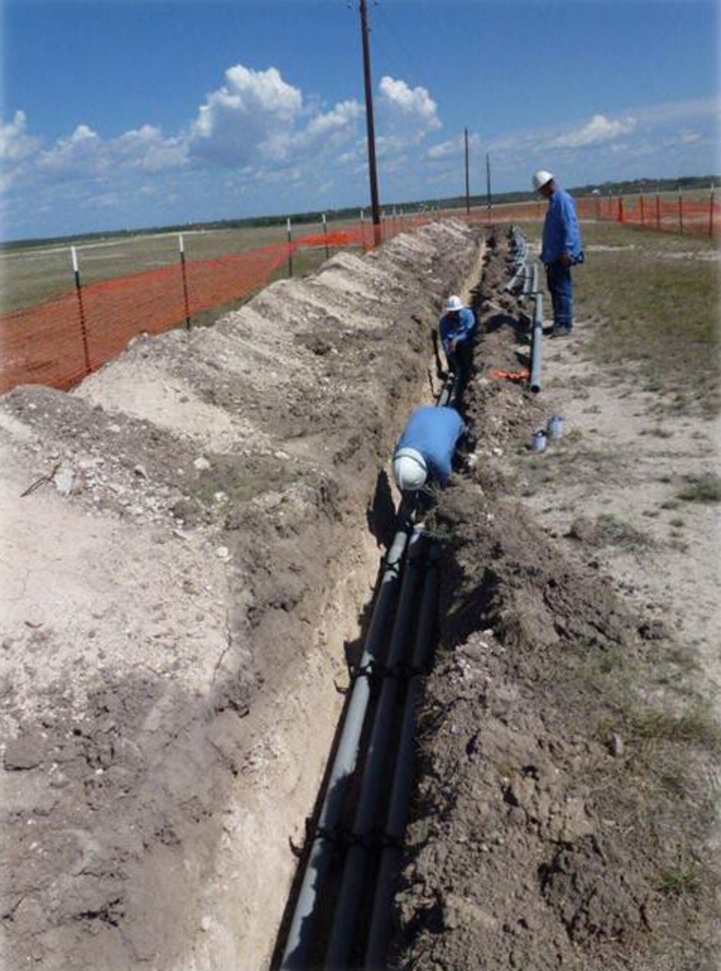 Crewmen from the Rio Grande Electrical Cooperative, place new electrical cables underground at the south end of Laughlin’s flight lines as part of the overhead to underground electrical distribution conversion project at Laughlin Air Force Base, Texas, November 2012. The project places pre-existing electrical and cable wiring underground to reduce maintenance costs, weather-related damages and power fluctuations that often lead to pauses in power and blackouts. (Contributed photo) 