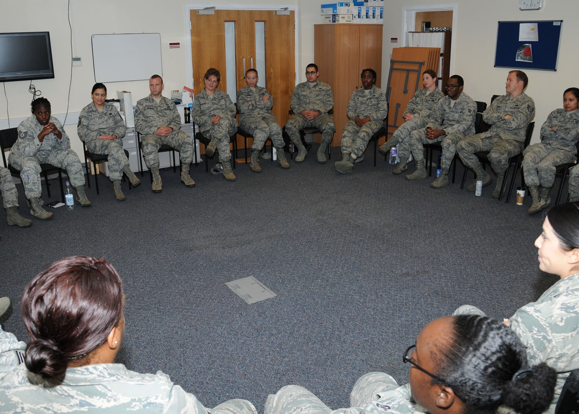 Personnel from the Sexual Assault Prevention and Response office and Team Mildenhall victim advocates speak with U.S. Air Force Col. David Cox, 100th Air Refueling Wing vice commander, during a meeting in the SARC building Oct. 3, 2013, on RAF Mildenhall, England. They discussed many areas of sexual assault prevention, including not focusing solely on Airmen in the dormitories but also trying the change the mindset of keeping ones problems to oneself. The VAs want to encourage everyone to come forward for help. (U.S. Air Force photo by Gina Randall/Released)