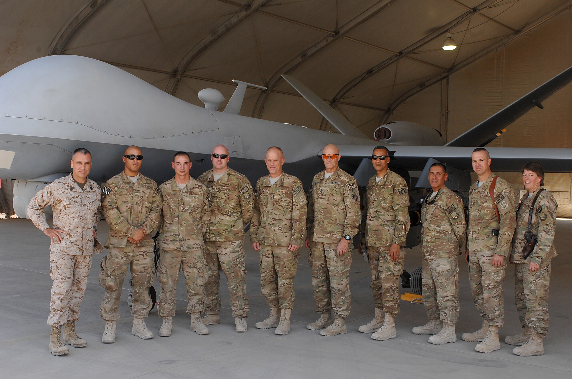 U.S. Marine Corps Sgt. Maj. James Booker, International Security Assistance Force and United States Forces-Afghanistan senior enlisted leader, and U.S. Army Command Sgt. Maj. Scott Schroeder, ISAF Joint Command sergeant major, pose for a group photo with members of the 451st Expeditionary Aircraft Maintenance Squadron during a visit to Kandahar Airfield, Afghanistan Sept. 23, 2013. The two enlisted leaders visited KAF in an effort to understand the missions of the base and meet with different servicemembers. (U.S. Air Force photo by Senior Airman Jack Sanders)
