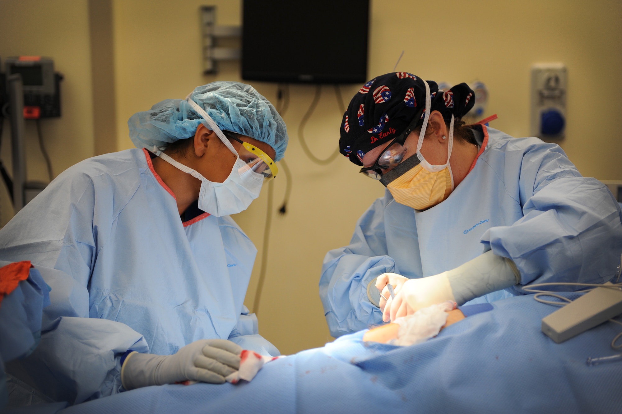 (From left) Airman 1st Class Sylvia Zamora watches Lt. Col. (Dr.) Sandra Early teaches her how to properly close a wound, Sept. 25, 2013, at Aviano Air Base, Italy. To anticipate what tool a surgeon will need next, a surgical technician must be as familiar with the procedure as the surgeon. Early is the surgical services medical director and Zamora is a surgical technician, both part of the 31st Surgical Operations Squadron. (U.S. Air Force photo/Airman 1st Class Matthew Lotz)