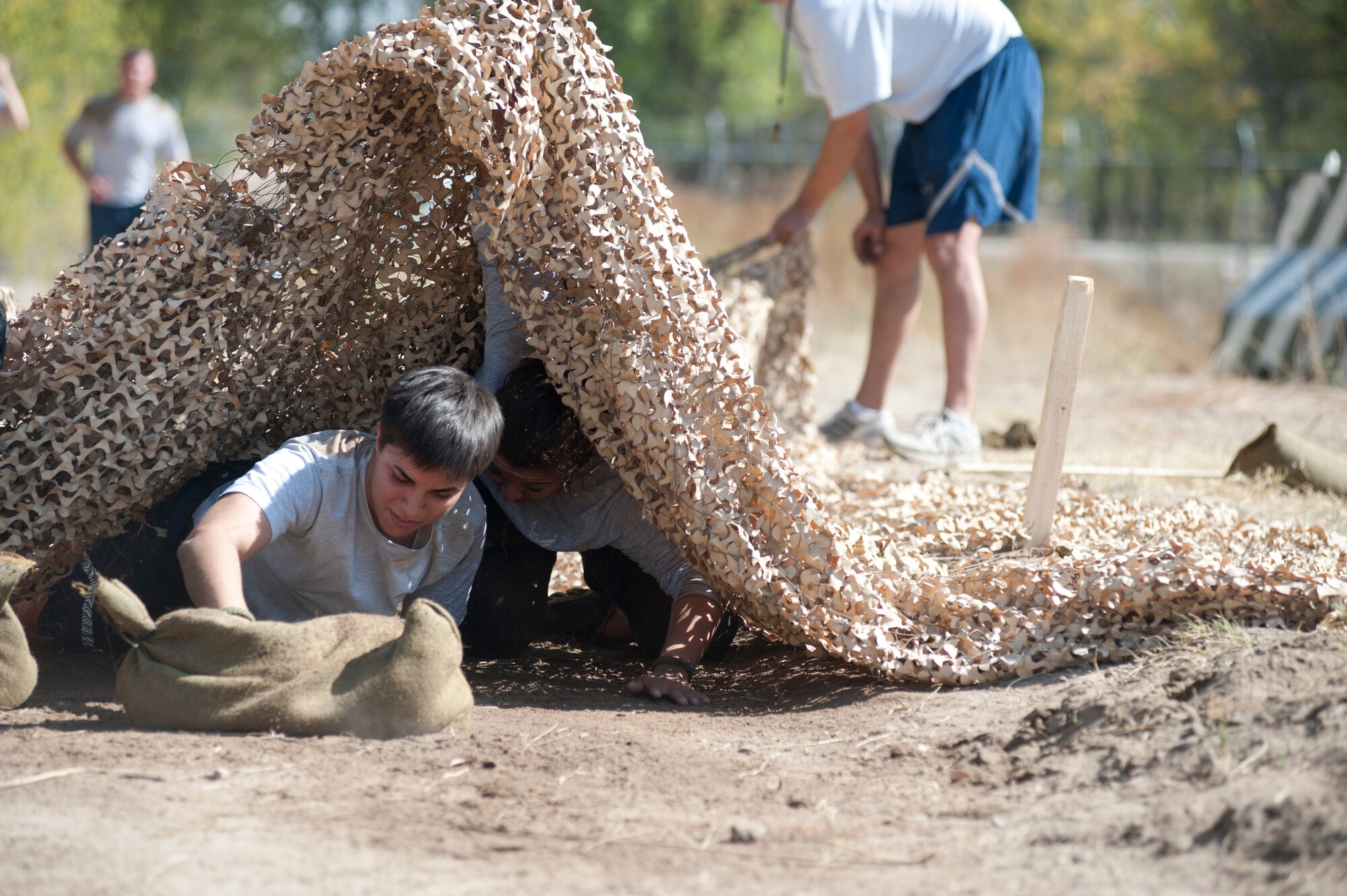 Tech. Sgt. Wendy Corbett low-crawls during the "Filthy 5K" event at Transit Center at Manas, Kyrgyzstan, Sept. 29, 2013. Corbett is a member of the 376th Expeditionary Security Forces Squadron deployed out of Maxwell Air Force Base, Ala., and a native of Goldsboro, N.C. (U.S. Air Force photo/Staff Sgt. Robert Barnett)