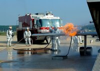 Airmen from the 8th Civil Engineer Squadron fire department extinguish a fire during an aircraft fire training scenario at Kunsan Air Base, Republic of Korea, Oct. 1, 2013. This training was part of exercise Beverly Midnight 13-4 and ensures the fire dogs are always ready for any situation. (U.S. Air Force photo by Staff Sgt. Jessica Haas/Released)