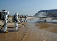 Airmen from the 8th Civil Engineer Squadron fire department extinguish a fire during an aircraft fire training scenario at Kunsan Air Base, Republic of Korea, Oct. 1, 2013. This training was part of exercise Beverly Midnight 13-4 and ensures the fire dogs are always ready for any situation. (U.S. Air Force photo by Staff Sgt. Jessica Haas/Released)