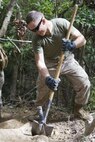 Pfc. Marshall T. Cox digs out dirt to form a stairway during construction of an endurance course Oct. 1 at Camp Hansen. The course is made up of approximately three miles of steep hills, deep ravines and narrow pathways through the jungle. Cox is a combat engineer with the 9th Engineer Support Battalion, 3rd Marine Logistics Group, III Marine Expeditionary Force.