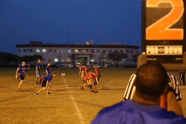 Players from the Dental (Blue) and the Deizlz (Red) form up on the line of scrimmage during an intramural flag football game behind the Robert M. Casey Medical and Dental Clinic aboard Marine Corps Air Station Iwakuni, Japan, Oct. 3, 2013. The Deizlz began this offensive drive with a quick quarterback sneak for a 10-yard gain.  