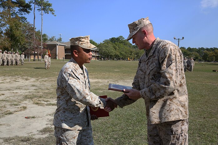 Brig. Gen. Edward D. Banta (right), the commanding general of 2nd Marine Logistics Group, congratulates Lt. Col. Ferdinand F. Llantero, the commanding officer of 8th Engineer Support Battalion, 2nd MLG, during a battalion award ceremony aboard Camp Lejeune, N.C., Oct. 2, 2013. The battalion received the Marine Corps Engineer Association Engineer Support Battalion of the Year for the eighth time in 16 years.