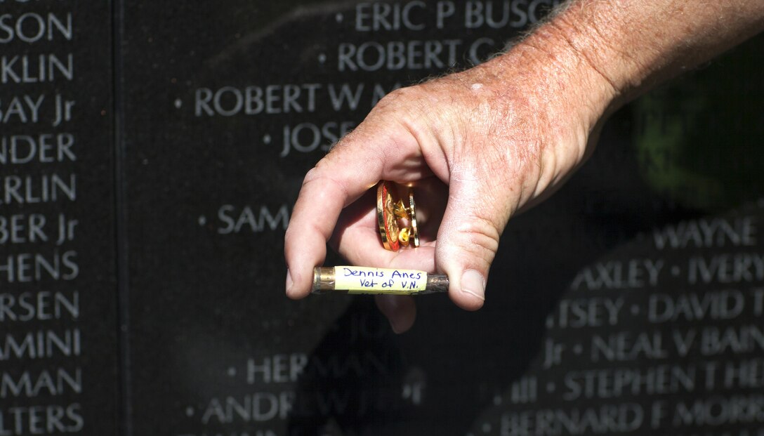 Marine Veteran Sgt. Chuck Lewis leaves a shell casing that holds the ashes of a Vietnam veteran at the Vietnam memorial. Lewis placed items; he had been given, on the wall for veterans of the Vietnam War. (Official U.S. Marine Corps photo by Lance Cpl. Dylan Bowyer/Released) 