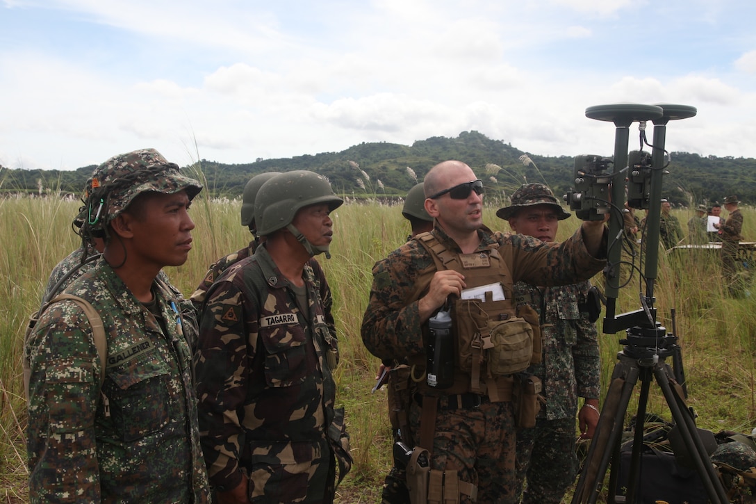 U.S. Marine Sgt. Reid L. Griffin discusses the purpose of establishing a proper orientation for directing a M101 105-mm Towed Howitzer with Philippine Marine and Army personnel during Amphibious Landing Exercise (PHIBLEX) 2014 at the Crow Valley Range Complex in Tarlac province, Republic of the Philippines. Bilateral Philippine-U.S. Marine Corps training sustains and reinforces the foundation and framework for a bilateral force to respond rapidly and effectively to regional humanitarian crises. Griffin is an artillery meteorological man with Battalion Landing Team 1st Battalion, 4th Marine Regiment, 13th Marine Expeditionary Unit. (Photo by Lance Cpl. David Hersey)