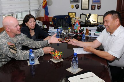 Army Brig. Gen. Mike Bridges, left, assistant adjutant general for Army, Alaska Army National Guard, exchanges gifts with Dumaa Namsrai, right, deputy chief of the Mongolia National Emergency Management Agency at the NEMA office in Ulaanbaatar, Mongolia, Aug. 13, 2012. Bridges attended the meeting while in Mongolia as part of the National Guard State Partnership Program.