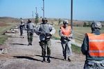 Sgt. 1st Class Paul Deegan, right, leads Ghanaian army soldiers off of the pop-up target marksmanship range at Camp Grafton Training Center in Devils Lake, N.D., Sept. 18, 2011. The Ghanaian soldiers visited North Dakota as part of an engineer instructor exchange under the State Partnership Program. North Dakota and Ghana have been partners under the program since 2004.