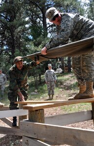 Suriname Army Maj. Richardo Breinburg hands Spc. Frank Doll, with the South Dakota Army National Guard, a stretcher while conducting a task on the Leader Reaction Course at West Camp Rapid, S.D., as part of the South Dakota Guard's Golden Coyote training exercise June 11, 2012. The South Dakota Guard hosted military leaders from the Republic of Suriname for a week long Subject Matter Expert Exchange.