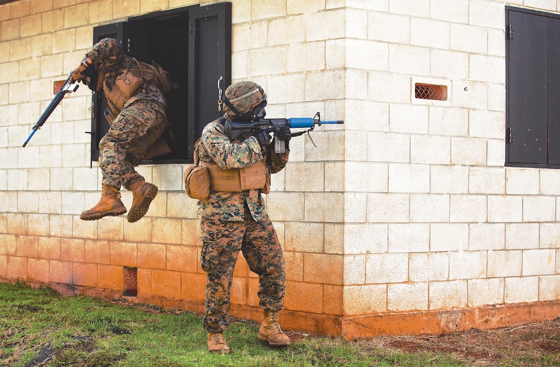 Lance Cpl. Benjamin Shoults, an automatic rifleman with first squad, third platoon, Bravo Company, 1st Battalion, 3rd Marine Regiment, and 21-year-old native of North Reading, Mass., right, provides security for fellow Marines during an assault and extraction exercise at a Military Operations in Urban Terrain facility at Kahuku Training Area Oct. 1, 2013.(U.S. Marine Corps photo by Lance Cpl. Matthew Bragg)