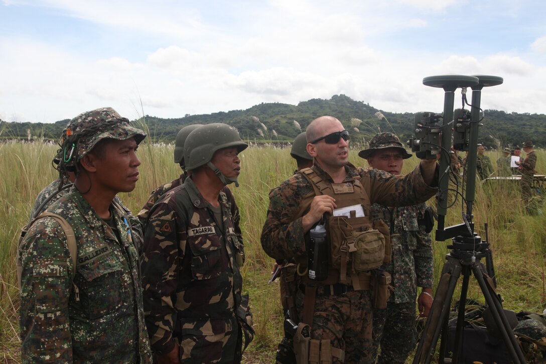 U.S. Marine Sgt. Reid L. Griffin discusses the purpose of establishing a proper orientation for directing a M101 105-mm Towed Howitzer with Philippine Marine and Army personnel during Amphibious Landing Exercise (PHIBLEX) 2014 at the Crow Valley Range Complex in Tarlac province, Republic of the Philippines. Bilateral Philippine-U.S. Marine Corps training sustains and reinforces the foundation and framework for a bilateral force to respond rapidly and effectively to regional humanitarian crises. Griffin is an artillery meteorological man with Battalion Landing Team 1st Battalion, 4th Marine Regiment, 13th Marine Expeditionary Unit. (Photo by Lance Cpl. David Hersey)