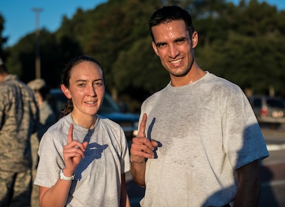 Left, Capt. Marie Harnly, 628th Civil Engineer Squadron Chief of Operations Engineering, and Right Capt. Sylvester, 628th CES Explosive Ordinance Disposal flight commander, hold up one finger signifying their first place finishes in the Commander’s Challenge Run Oct. 4, 2013, at Joint Base Charleston – Air Base, S.C. The Commander's Challenge is held monthly to test Team Charleston's fitness abilities. (U.S. Air Force photo/ Senior Airman Dennis Sloan)