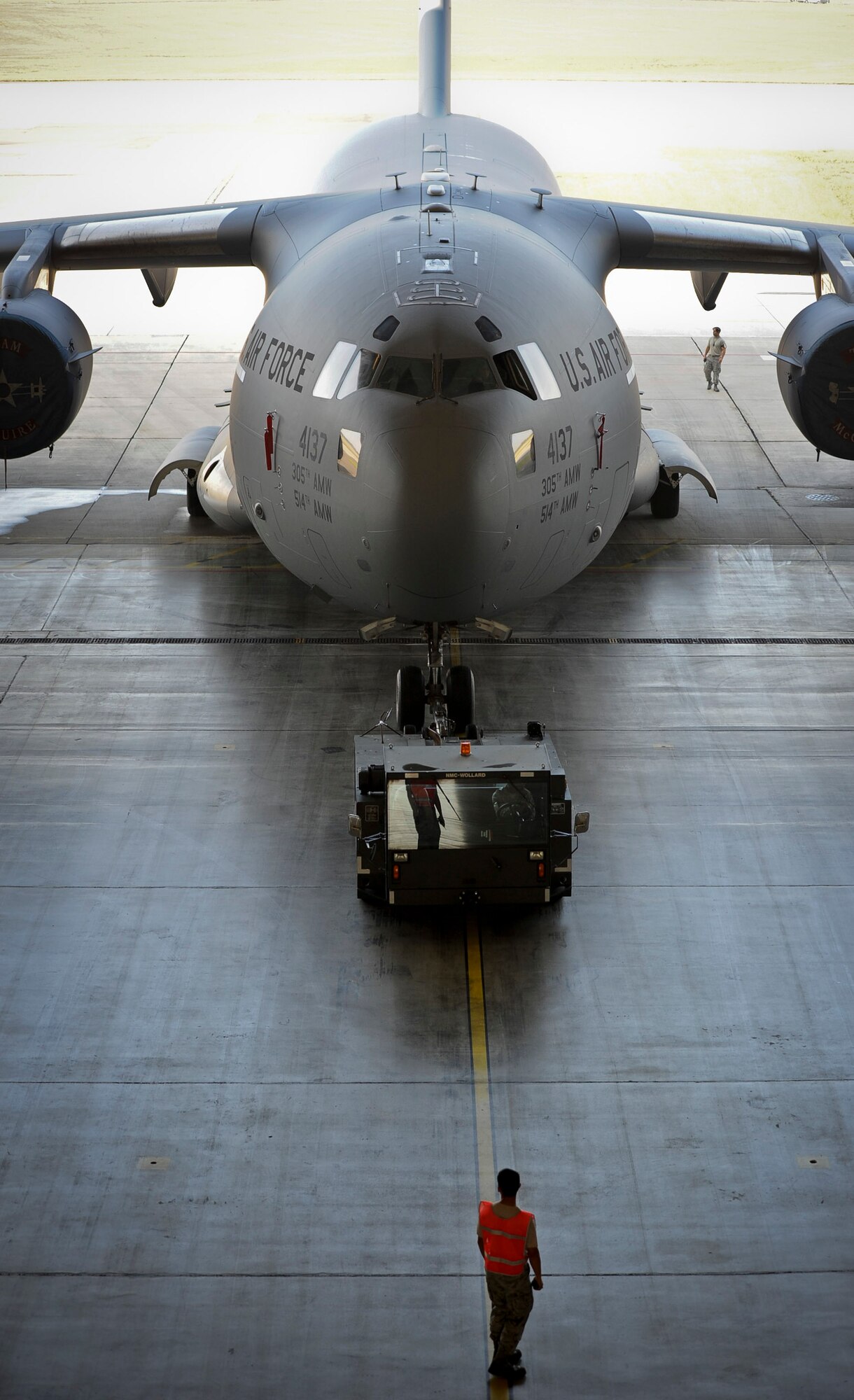A group of 305th Aircraft Maintenance Squadron Airmen marshal a C-17 Globemaster III into a hangar to be on display for a ceremony Oct. 4, 2013, on McGuire Field at Joint Base McGuire-Dix-Lakehurst, N.J.  (U.S. Air Force photo by Airman 1st Class Ryan Throneberry/Released)