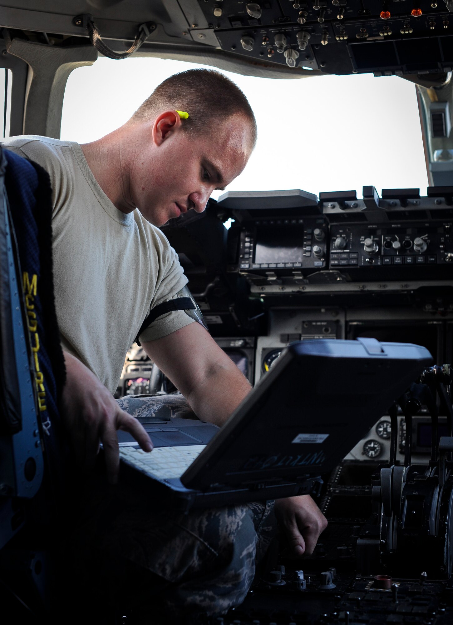 Staff Sgt. Anthony Presely, 305th Aircraft Maintenance Squadron flying crew chief, checks the computers in the cockpit of a C-17 Globemaster III, Oct. 4, 2013, on McGuire Field at Joint Base McGuire-Dix-Lakehurst, N.J. The flightline is still operating 24/7 despite the loss of civilian and air reserve technicians. (U.S. Air Force photo by Airman 1st Class Ryan Throneberry/Released)