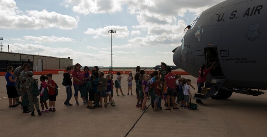 Children of Dyess Airmen wait to tour a C-130J during Operation Dyess Kids Sept. 27, 2013, at Dyess Air Force Base, Texas. The purpose of Operation Dyess Kids was to help children understand why parents deploy and what they go through during a deployment, as well as to encourage parent-child communication. (U.S. Air Force photo by Airman 1st Class Kylsee Wisseman/Released)