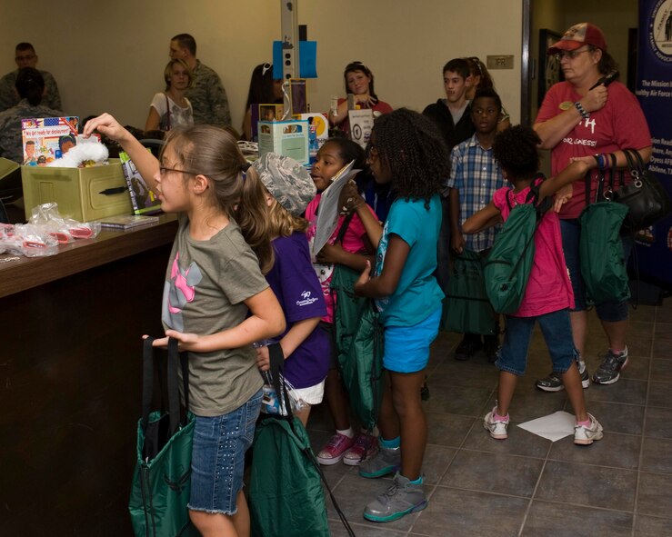 Children of Dyess Airmen go through a mock deployment line during Operation Dyess Kids Sept. 27, 2013, at Dyess Air Force Base, Texas. The children went through a mock deployment line, toured a C-130J and B-1, went through an obstacle course and attended a welcome home event. (U.S. Air Force photo by Airman 1st Class Kylsee Wisseman/Released)