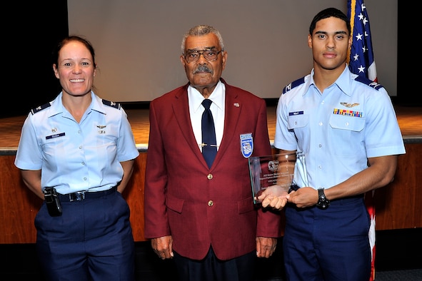Cadet Candidate Ryan Kelly (right) receives the Senior Master Sgt. Margaret Barbour Frances Award from Tuskegee Airman Franklin J. Macon (middle) and Col. Kabrena Rodda at the Community Center Theater Sept. 26. The award is presented to a noncommissioned officer who has exhibited outstanding performance in both professional and community service. (U.S. Air Force Photo/Sam Lee)
