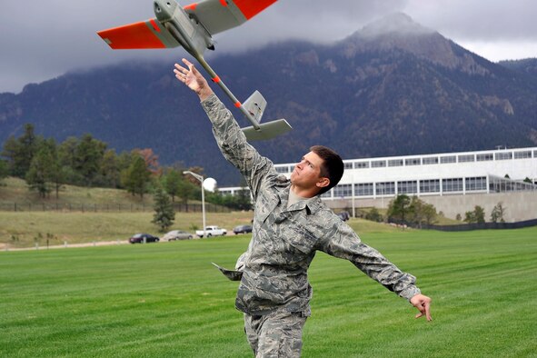 Cadet 2nd Class Jeremy Snell launches the RQ-11 Raven, a small hand-launched remote-controlled unmanned aerial system, at the Stillman Parade Field. Cadets will soon become evaluators in the Academy's unmanned aerial system program. (U.S. Air Force Photo/Liz Copan)
