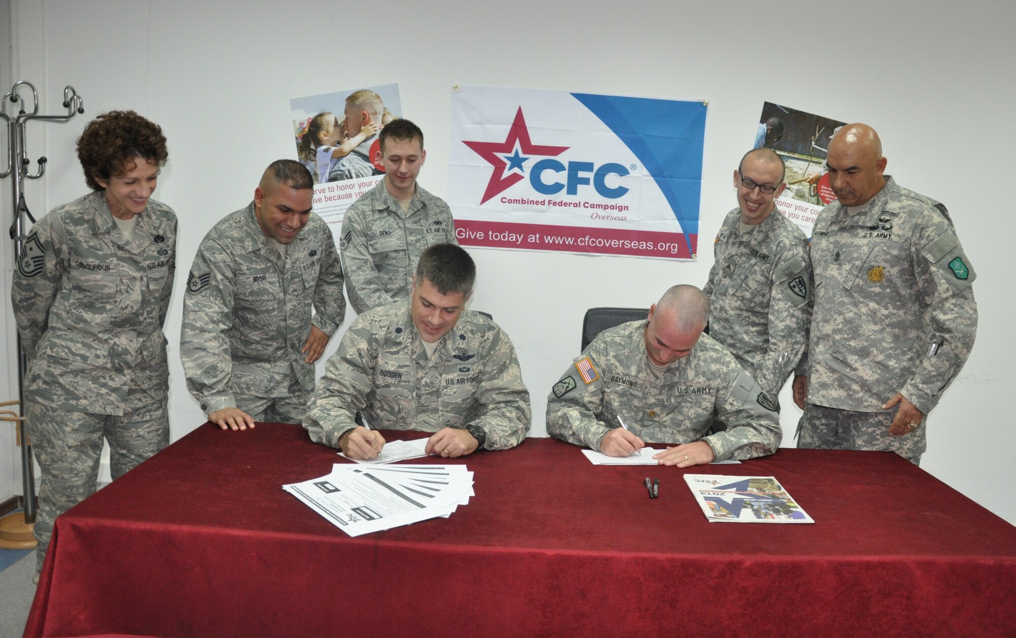 U.S. Air Force Lt. Col. Gary Goosen (left), 425th Air Base Squadron commander, and U.S. Army Maj. Ryan Raymond (right), United States Army NATO Regional Support Command-Türkiye commander, fill out the Combined Federal Campaign forms, Oct. 4, 2013. The CFC is the only Department of Defense authorized solicitation of federal employees in the workplace on behalf of charitable organizations. (Courtesy photo by Tanju Varlikli)